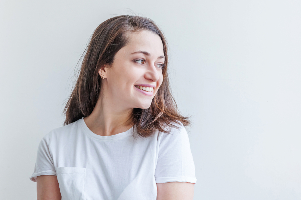 Mulher sorrindo com uma camiseta representando Janeiro Branco. 