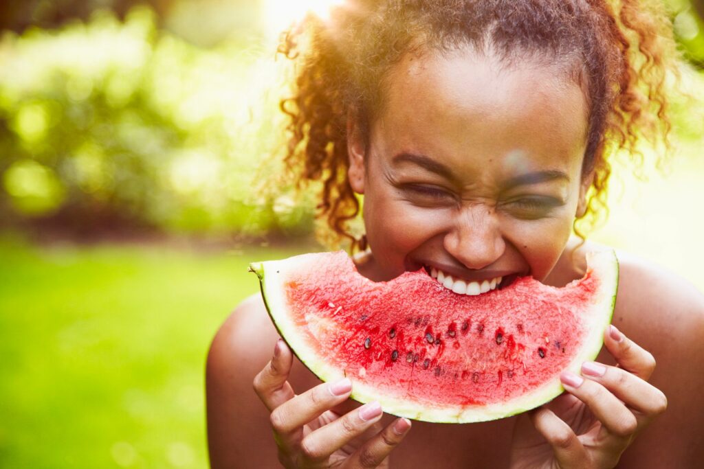 O que é alimentação saudável: mulher comendo melancia. 
