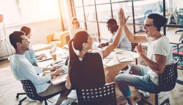 Colegas de trabalho reunidos em uma mesa durante uma reunião, referência burnout na profissão. 
