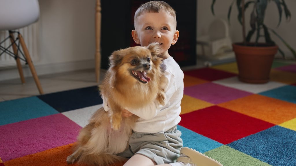 criança sorridente segurando um cachorro no colo